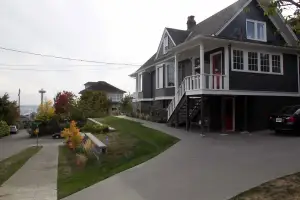 photo of a house on an incline, new driveway, and updated exterior rockery